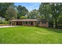 Charming brick home with an attached covered carport and a well-maintained front lawn surrounded by mature trees at 422 Derbyshire Dr, Stone Mountain, GA 30088