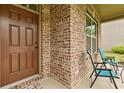Close-up of the front porch with brick columns and blue seating at 5310 Corinth Ct, Cumming, GA 30040