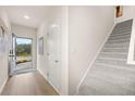 Bright entryway features wood floors, gray carpeted stairs, and a stylish blue front door at 1186 Westhampton Way # 134, Villa Rica, GA 30180