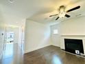 Bright, contemporary living room with hardwood floors, a fireplace, and a ceiling fan at 124 Auburn Run Ln, Auburn, GA 30011