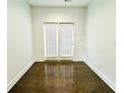 Bright room featuring hardwood flooring and double doors with a view to the outside at 124 Auburn Run Ln, Auburn, GA 30011