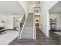 Bright foyer featuring a carpeted staircase, hardwood floors, and views into the living spaces at 1771 Deer Crossing Cir, Jonesboro, GA 30236
