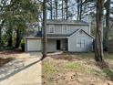 Two-story home featuring neutral siding, well-maintained yard and attached garage at 5463 Forest East Ln, Stone Mountain, GA 30088
