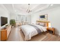 Serene bedroom showcases tray ceilings, modern lighting, and plush bedding for a relaxing retreat at 1600 Spring Arbor Sw Ct, Lilburn, GA 30047