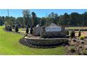 Wildwood Place community sign with stone base, manicured landscaping, and lush green surroundings at 4663 Larkfield Way, Powder Springs, GA 30127