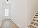 Bright entryway with wood-look floors, white walls, and a staircase with wood treads at 4663 Larkfield Way, Powder Springs, GA 30127