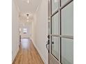 Inviting entryway featuring wood-look floors, white walls, and natural light from the glass-paneled door at 4663 Larkfield Way, Powder Springs, GA 30127