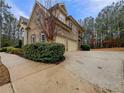 Spacious driveway leading to a three-car garage, surrounded by lush greenery at 6111 Sequoia Ln, Douglasville, GA 30135