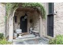 Covered stone entryway with arched brick detail and stylish lighting fixtures at 7455 Old Rico Rd, Chattahoochee Hills, GA 30268