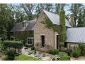 Charming stone home with metal roof, ivy-covered walls, and lush garden at 7455 Old Rico Rd, Chattahoochee Hills, GA 30268