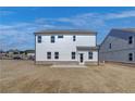 Backyard view of a two-story home showing vinyl siding, large windows and a concrete patio at 3941 Adler Cir, Buford, GA 30519