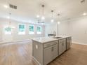 Open concept kitchen with white quartz countertops, stainless steel appliances, and pendant lighting at 4671 Larkfield Way, Powder Springs, GA 30127