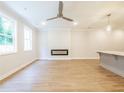 Bright living room featuring sleek hardwood floors, neutral paint, a ceiling fan, and an electric fireplace at 4671 Larkfield Way, Powder Springs, GA 30127