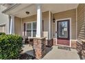 Inviting front porch featuring stone supports, neutral siding, and a stylish entry door, perfect for relaxing outdoors at 1531 Autumn Wood Trl, Buford, GA 30518