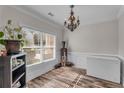Bright home office space with wood-look floors, chandelier, large window, and crisp white trim at 1531 Autumn Wood Trl, Buford, GA 30518