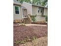 Front entrance with fresh mulch and a wooden stairwell entrance at 6739 Valley Ct, Douglasville, GA 30135