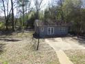 A view of the back exterior and backyard, which includes a back deck, yard and an outbuilding at 123 Oldenburg Dr, Riverdale, GA 30274