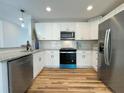 Bright kitchen with white cabinets, stainless steel appliances, granite countertops, and backsplash at 229 Evergreen Trail Unit C, Cartersville, GA 30121