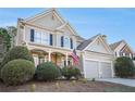 Beautiful home with a covered porch, two-car garage, and lush landscaping enhancing its curb appeal at 113 Windsong Trl, Canton, GA 30114