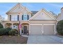 Traditional two-story home featuring a manicured front lawn, a two-car garage, and classic architectural details at 113 Windsong Trl, Canton, GA 30114