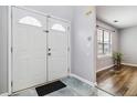 Inviting entryway featuring a double door, tile flooring, and view into a room with wood floors and bright window at 6274 Katelyn Park, Lithonia, GA 30058