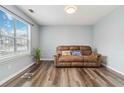Cozy living room with new wood flooring, natural light from a bright window, and a comfortable reclining sofa at 6274 Katelyn Park, Lithonia, GA 30058