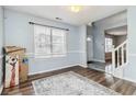 Open-concept living room showing wood flooring and light blue walls with a view of the entryway and staircase at 6274 Katelyn Park, Lithonia, GA 30058