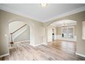 Open-concept living room featuring wood-look floors, crown molding, and arched doorways at 217 Park Creek Dr, Woodstock, GA 30188