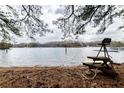 Peaceful lake view with a rustic dock and calm water, surrounded by trees at 4020 F A A Rd, Cumming, GA 30041