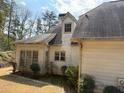 Side view of home with dark shingle roof, light siding, and small bushes at 4508 Bankside Court, Marietta, GA 30066