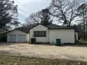 View of detached two-car garage with white siding and ample driveway space at 684 S Hairston Rd, Stone Mountain, GA 30088