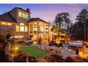 Luxurious backyard oasis featuring a covered patio, hot tub, outdoor kitchen, and beautiful landscaping at 78 Cuthbert Ln Ne, Acworth, GA 30101