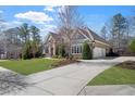 Charming home featuring well-manicured lawn, stone accents, arched windows, and a spacious driveway at 78 Cuthbert Ln Ne, Acworth, GA 30101