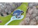 Aerial view of estate home showing lush lawn, long driveway, swimming pool and hot tub surrounded by dense mature trees at 4233 Sandstone Shores Dr, Stonecrest, GA 30038