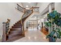 Grand foyer showcasing a curved staircase, detailed ironwork, and elegant tile flooring at 4233 Sandstone Shores Dr, Stonecrest, GA 30038