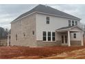 Rear view of a home with brick and gray siding, large windows, and a covered patio at 6945 Melody Ridge Rd, Buford, GA 30518