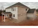 Angle view of the rear of a two story home that shows the roof, windows and patio at 6945 Melody Ridge Rd, Buford, GA 30518