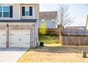 Side view of backyard, with garage and privacy fence, showing potential for outdoor enjoyment at 2436 Planters Mill Way, Conyers, GA 30012