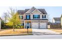 Traditional two-story home featuring brick accents, a two-car garage, and a well-kept lawn at 2436 Planters Mill Way, Conyers, GA 30012