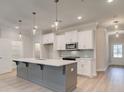 Modern kitchen with stainless steel appliances, a large island, and stylish pendant lighting at 1604 Ruskin Way, Marietta, GA 30062