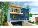 Modern home showcasing a striking blue exterior with a balcony and a well-manicured front yard at 237 Altoona Sw Pl, Atlanta, GA 30314