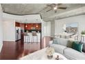 Open concept living and kitchen area featuring hardwood floors, concrete ceiling, and a stylish island with bar seating at 250 Pharr Ne Rd # 318, Atlanta, GA 30305