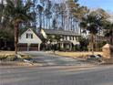 Lovely two-story home with a paved driveway and a well-manicured lawn adorned with palm trees at 4970 Lakeland Woods Ct, Atlanta, GA 30338