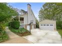 View of the house exterior, showing the garage, lush landscaping, and a basketball hoop at 345 Lambeth Dr, Hiram, GA 30141