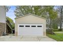 A large, detached garage with a white door and neutral siding, offers ample parking at 345 Lambeth Dr, Hiram, GA 30141