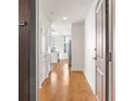 Hallway with hardwood floors leads to an open, modern kitchen and living area at 44 Peachtree Nw Pl # 1328, Atlanta, GA 30309
