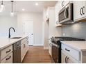 Bright kitchen featuring stainless steel appliances, white cabinetry and countertops with black hardware at 4523 Moray Dr, Mableton, GA 30126