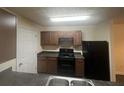 Functional kitchen with a black refrigerator, stove, and dark countertops at 5101 Fairington Club Dr, Lithonia, GA 30038