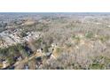 An aerial view of a wooded community, featuring mature trees and houses at 5770 Millstone Dr, Cumming, GA 30028