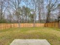 A large fenced backyard provides privacy and a sense of nature, with the forest just beyond the property at 7006 Mahonia Pl, Lithonia, GA 30038